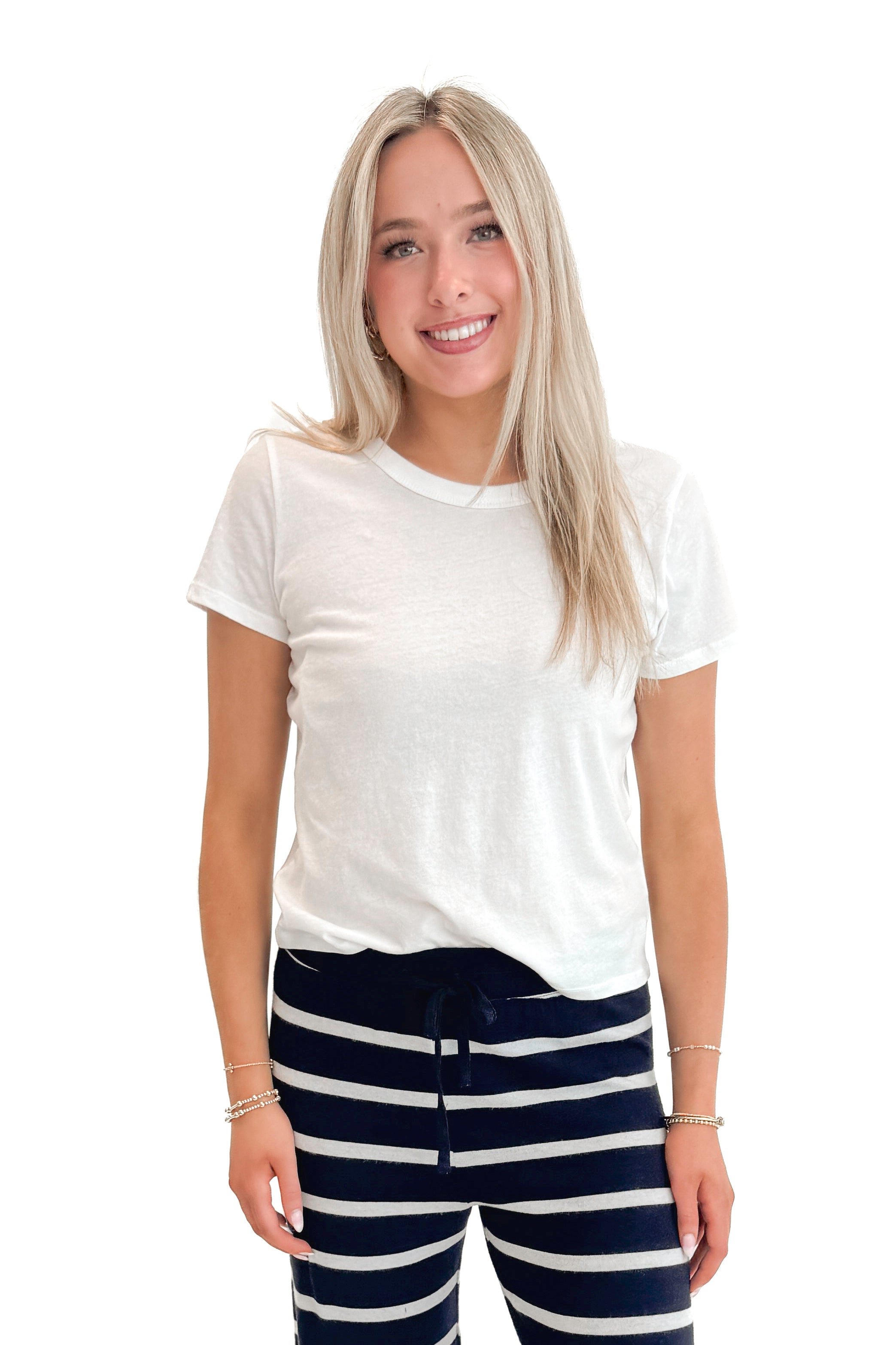 Front view of woman wearing White Junie Tee Shirt by Z Supply with pants against white studio background.