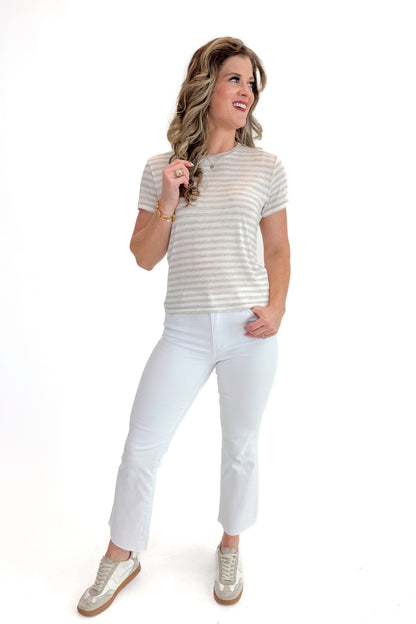 Front view of woman wearing Natural Heather Tourist Striped Tee with jeans against white studio background.