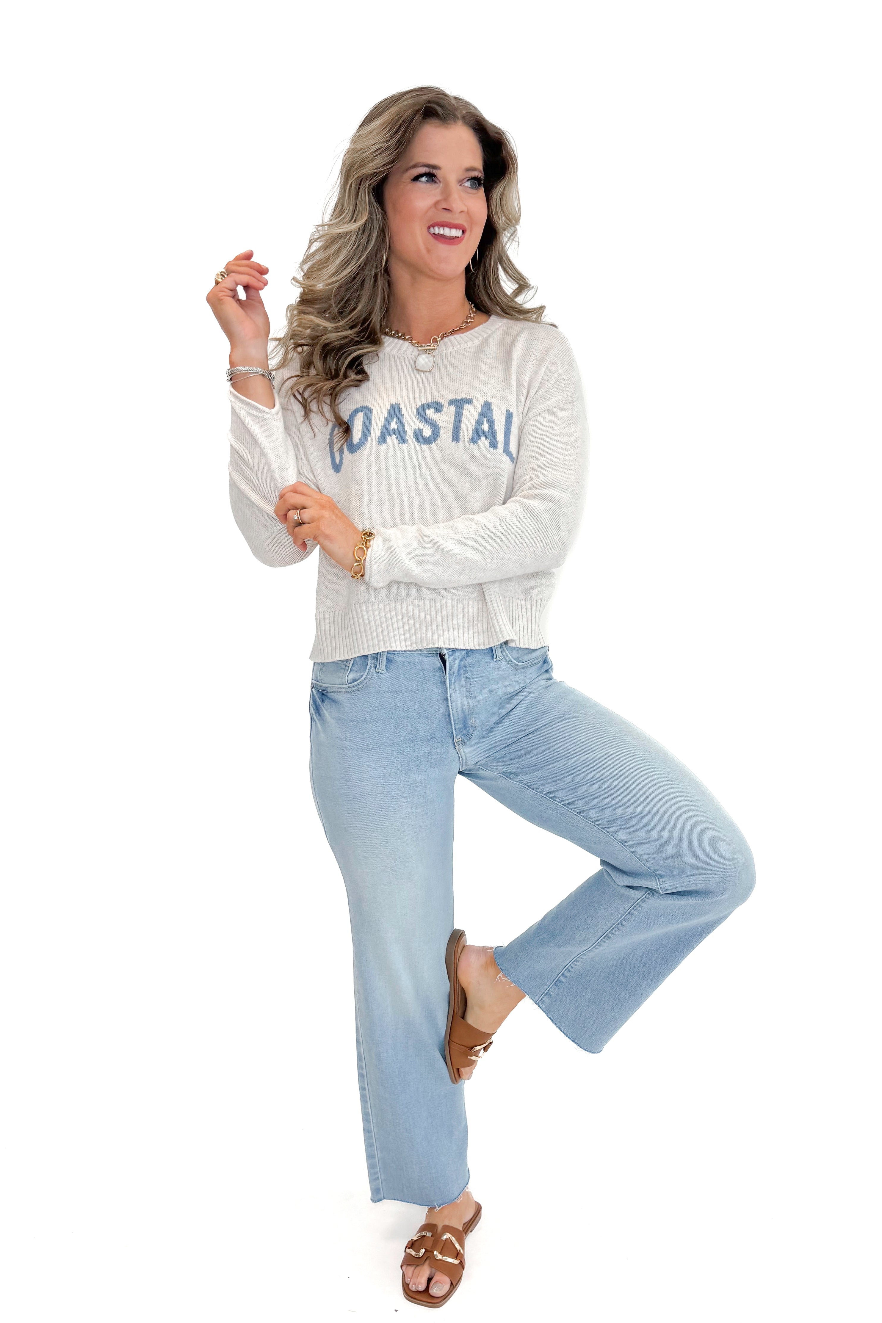 Front view of woman wearing Light Heather Oatmeal Sienna Coastal Sweater by Z Supply with jeans against white studio background.