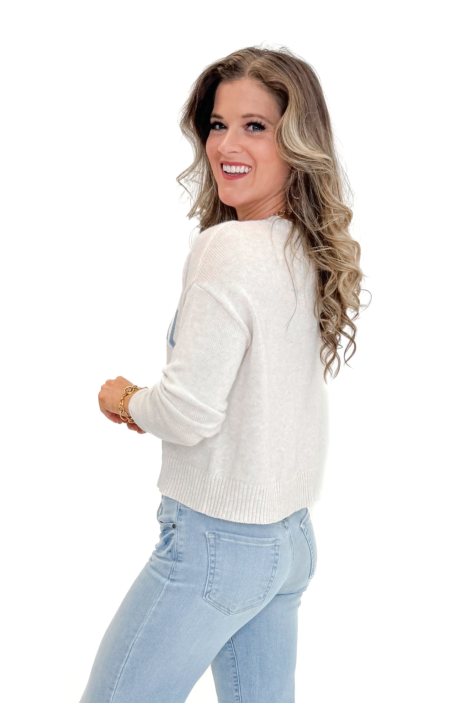 Side view of woman wearing Light Heather Oatmeal Sienna Coastal Sweater by Z Supply with jeans against white studio background.