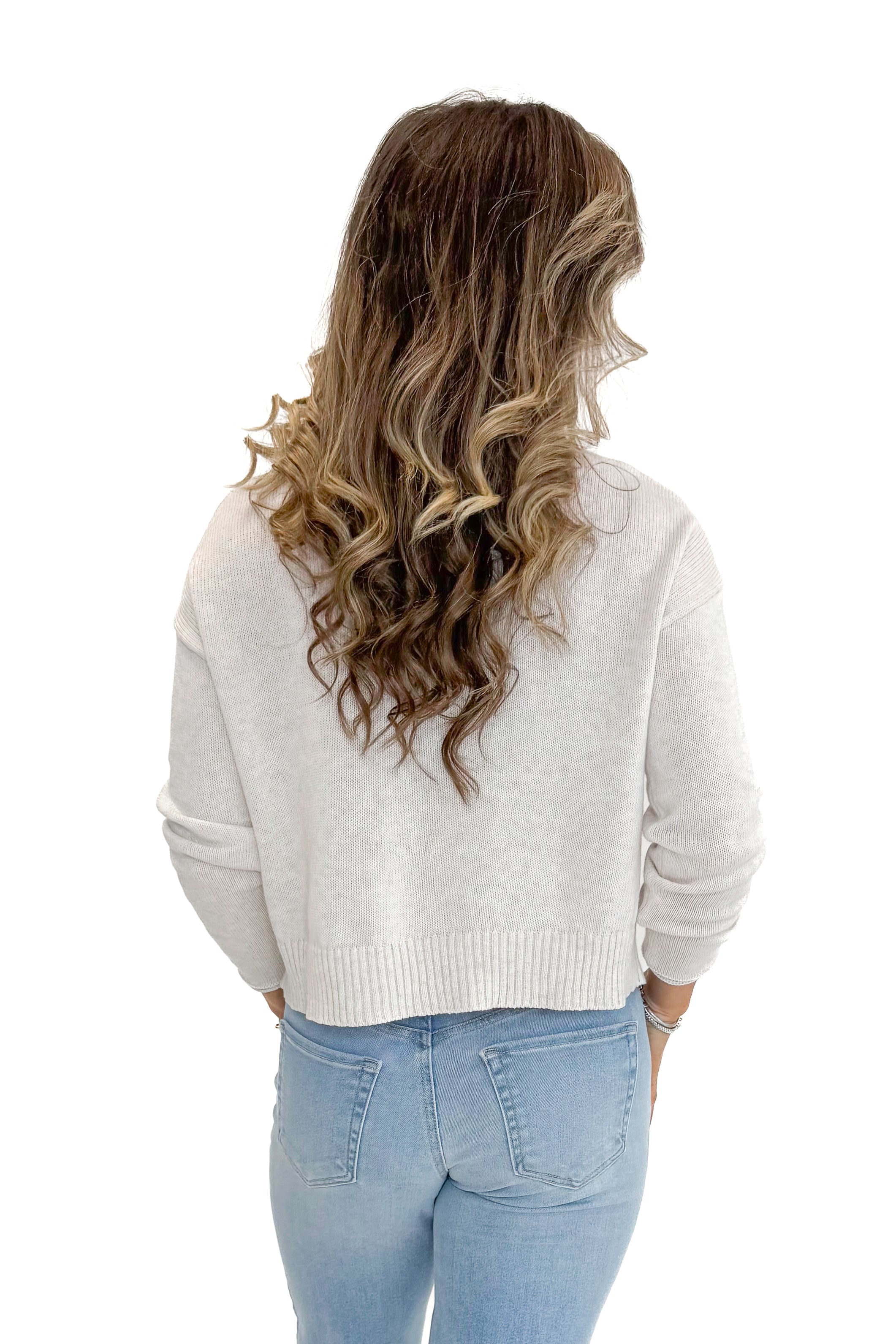 Back view of woman wearing Light Heather Oatmeal Sienna Coastal Sweater by Z Supply with jeans against white studio background.