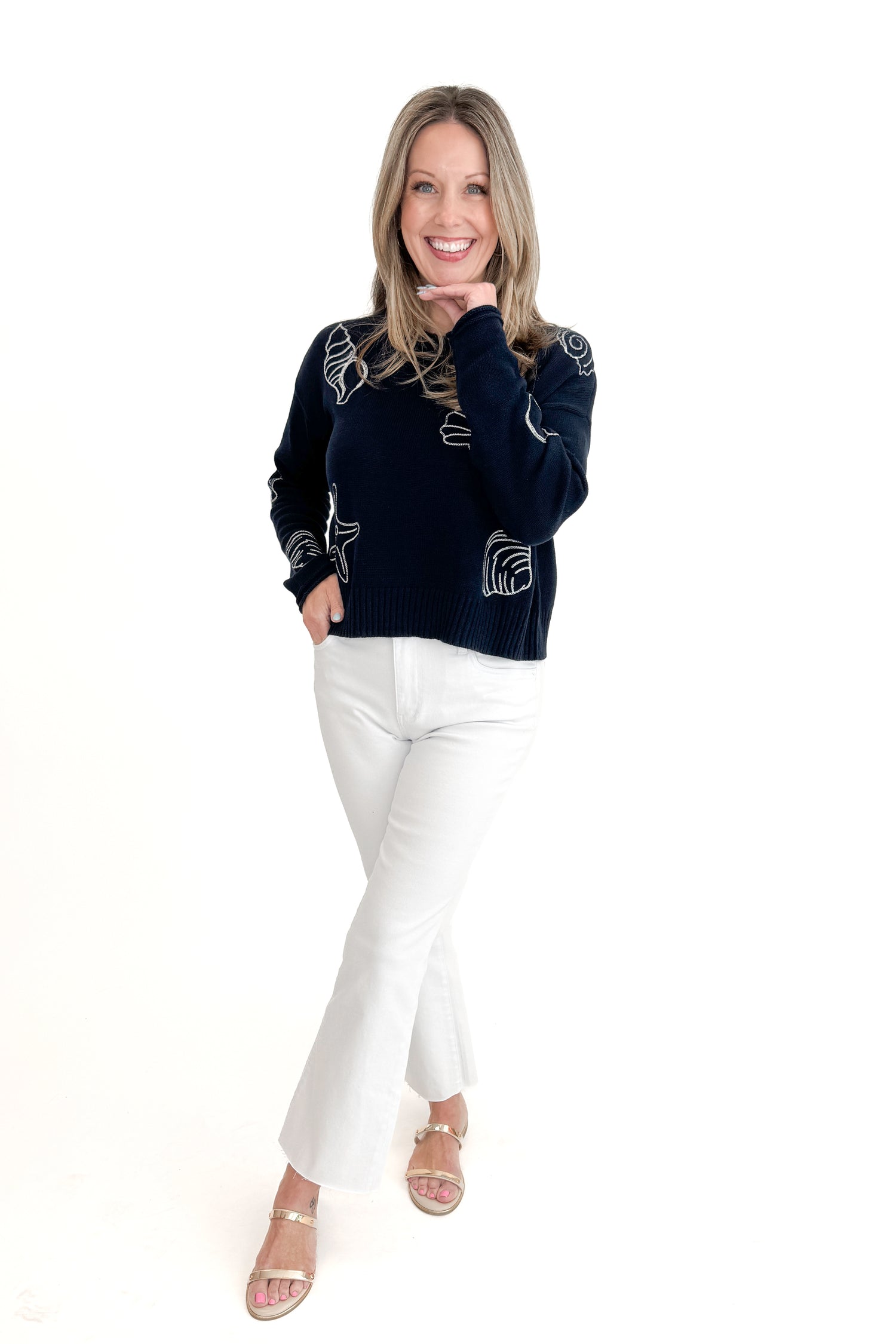 Front view of woman wearing True Navy Paradise Reef Sienna Sweater by Z Supply with jeans against white studio background.