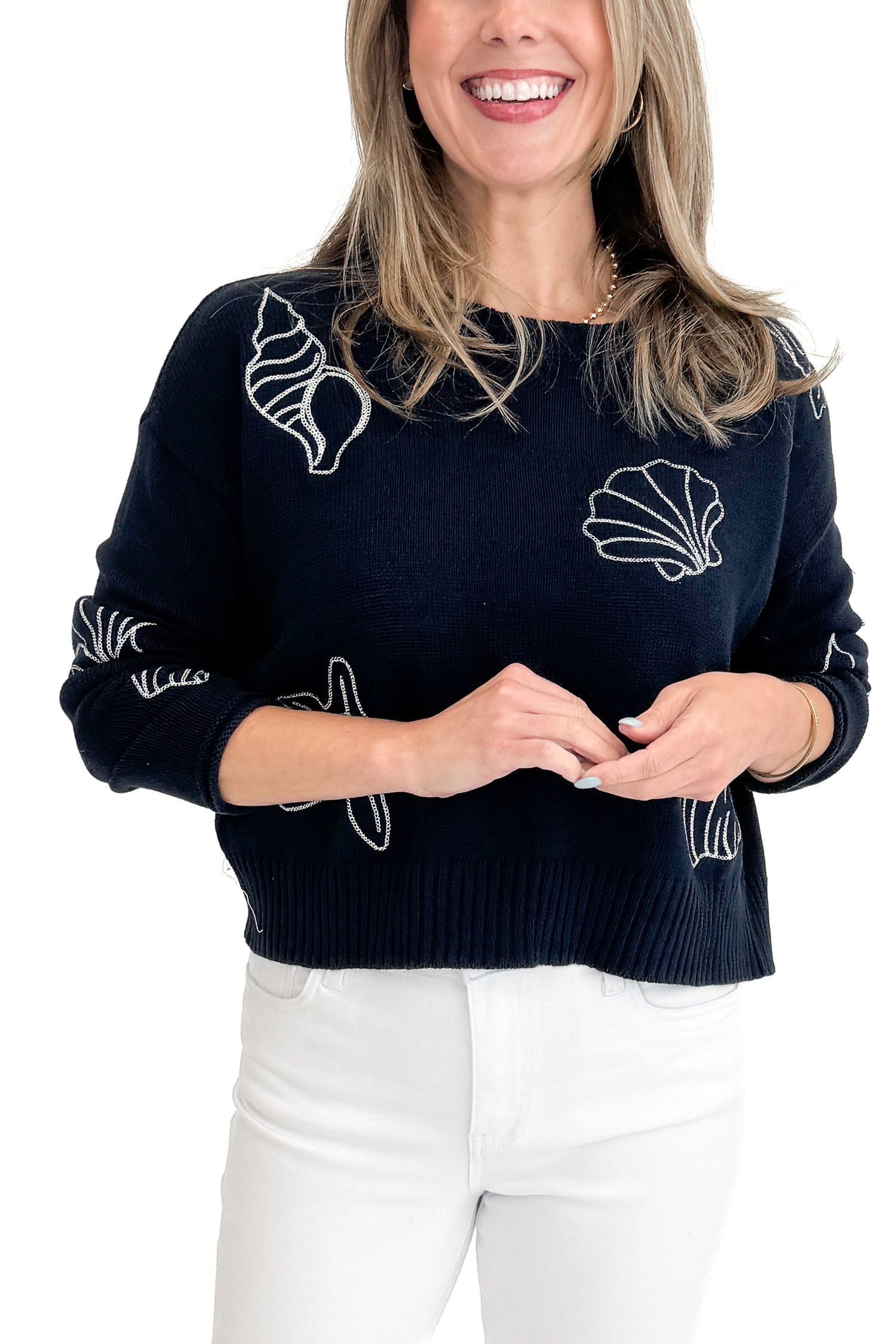 Front detail view of woman wearing True Navy Paradise Reef Sienna Sweater by Z Supply with jeans against white studio background.