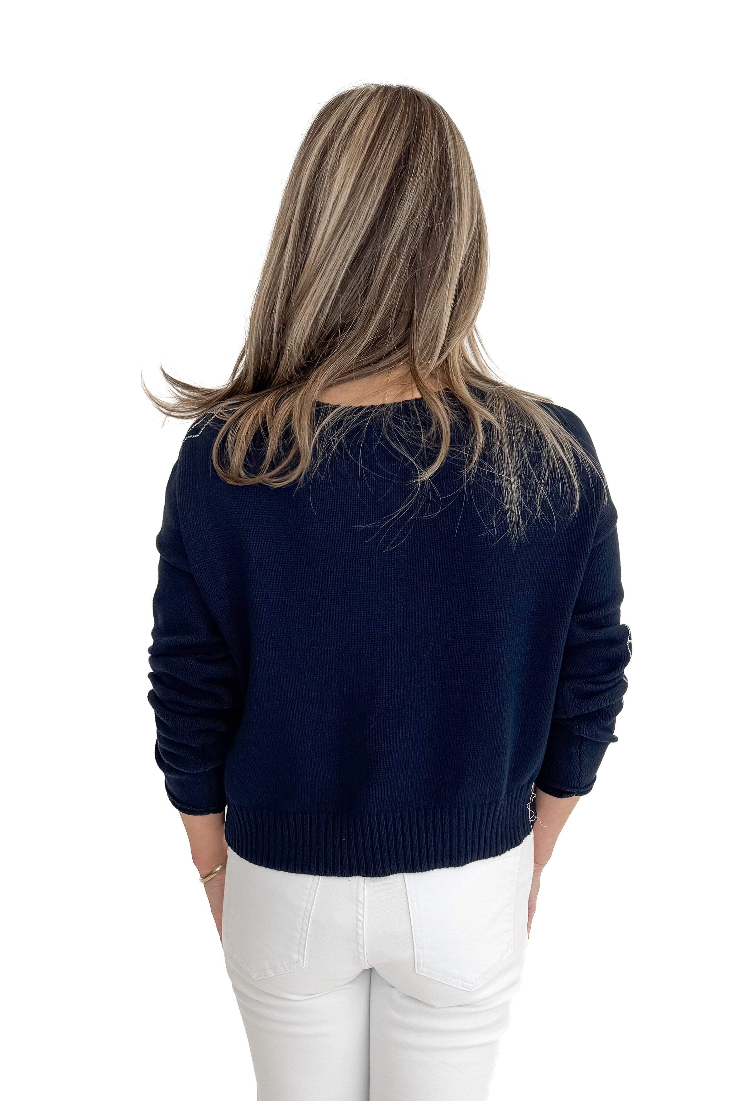 Back view of woman wearing True Navy Paradise Reef Sienna Sweater by Z Supply with jeans against white studio background.