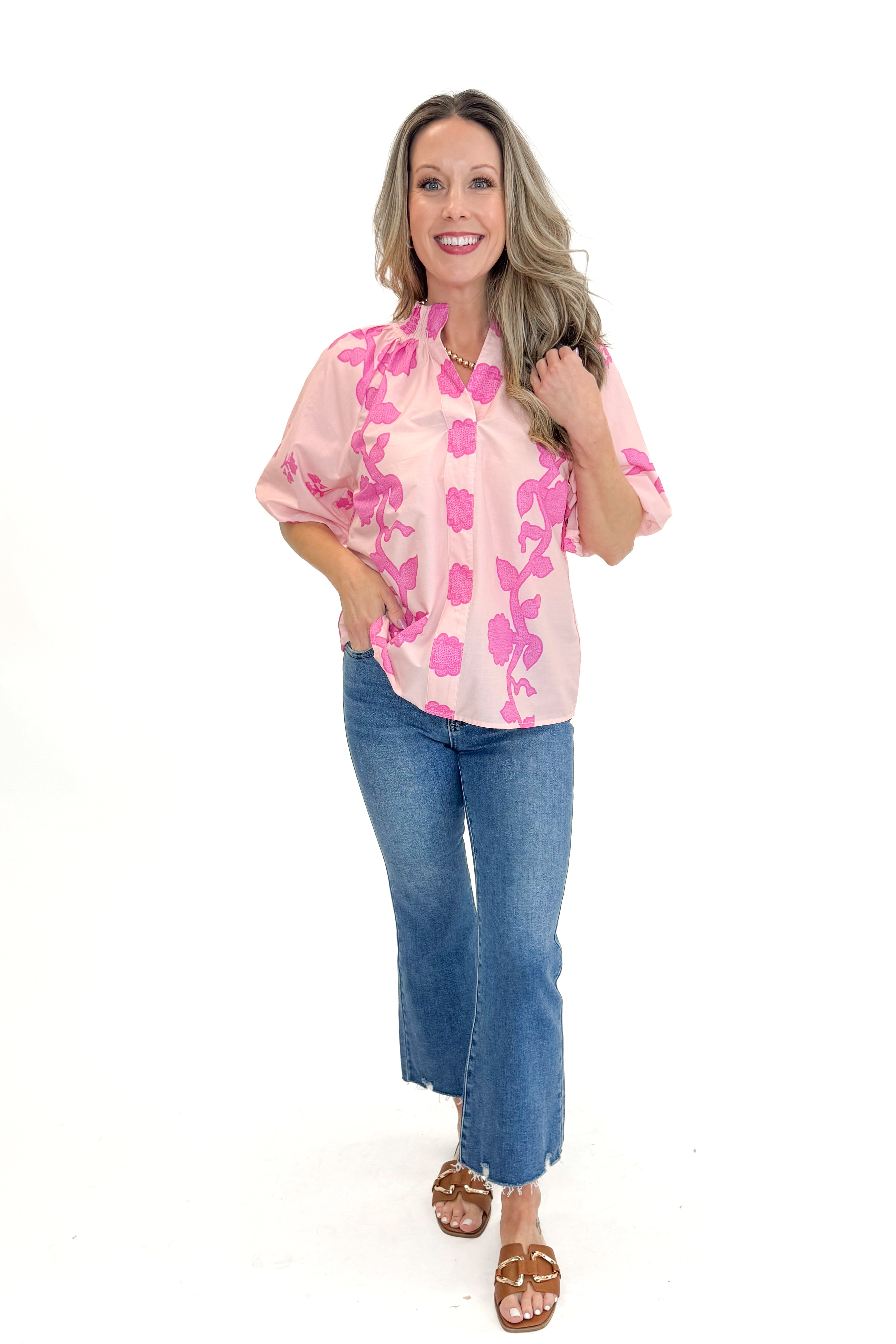 Front view of woman wearing Pink Floral Lace Print Top with jeans against white studio background.