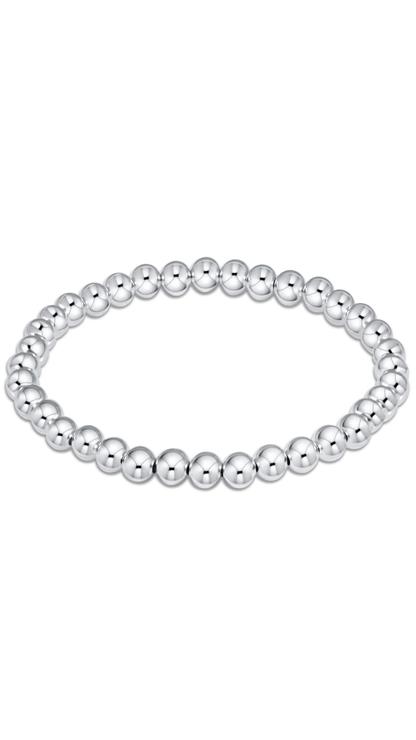 A stretch bracelet made of polished silver-colored metallic beads, arranged in a horizontal oval on a solid white background.