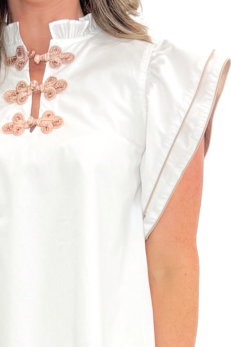 Front detail view of woman wearing White With Taupe Piping Detail Top with jeans against white studio background.