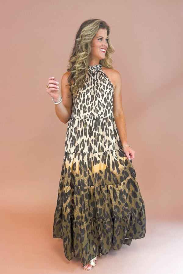 Woman in a leopard print dress standing in front of a beige background