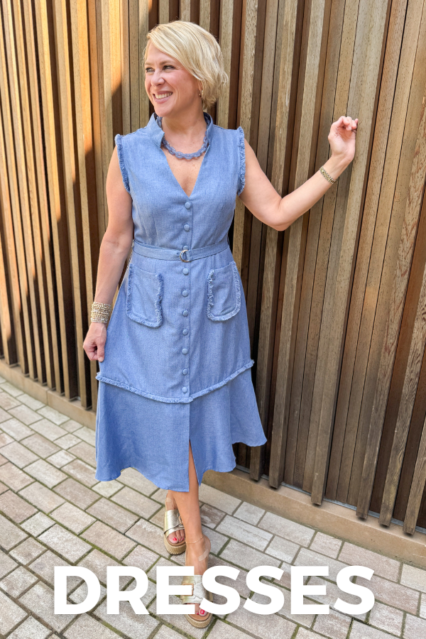 Woman wearing a blue dress standing against a wooden wall with 'DRESSES' text overlay.