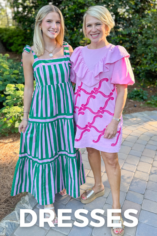 Two women standing outdoors wearing green and pink dresses with text overlay 'DRESSES'.