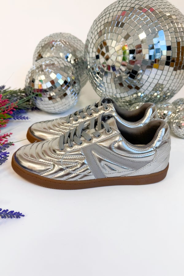 Silver disco ball sneakers with reflective surface on a white background