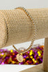 A delicate gold beaded bracelet with a small round charm displaying the ecu mascot