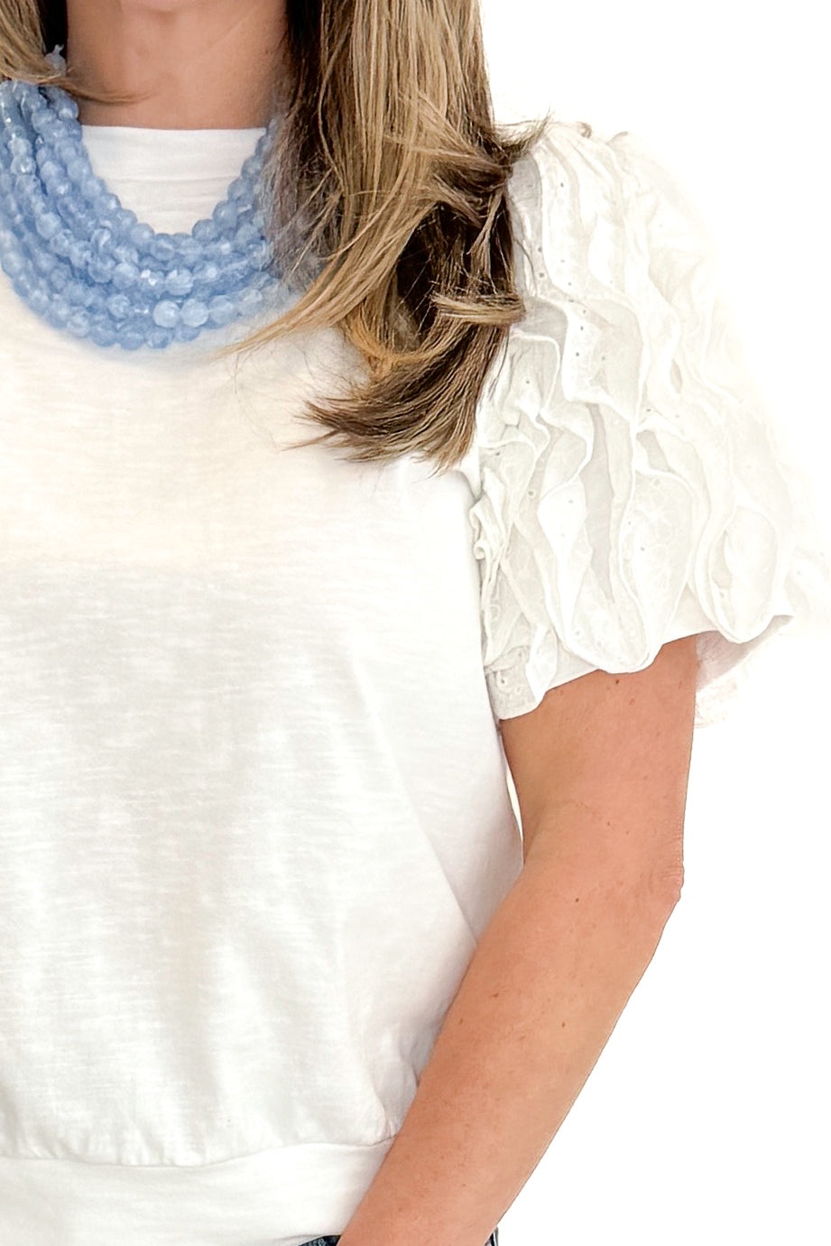 Front detail view of woman wearing White Ruffle Sleeve Detail Top by Fate with jeans against white studio background.