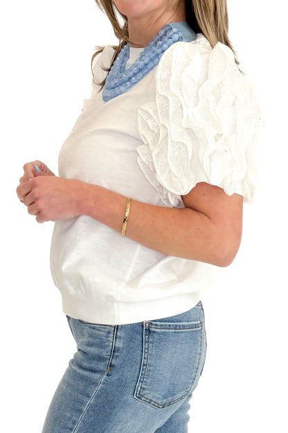 Side detail view of woman wearing White Ruffle Sleeve Detail Top by Fate with jeans against white studio background.