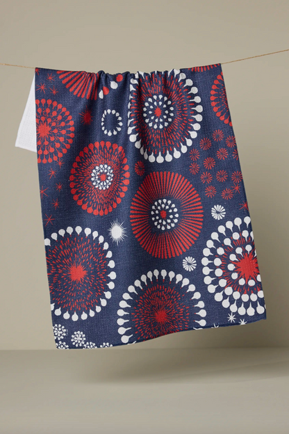 Navy blue towel with red and white circular patterns hanging on a line against a beige background
