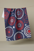 Navy blue towel with red and white circular patterns hanging on a line against a beige background