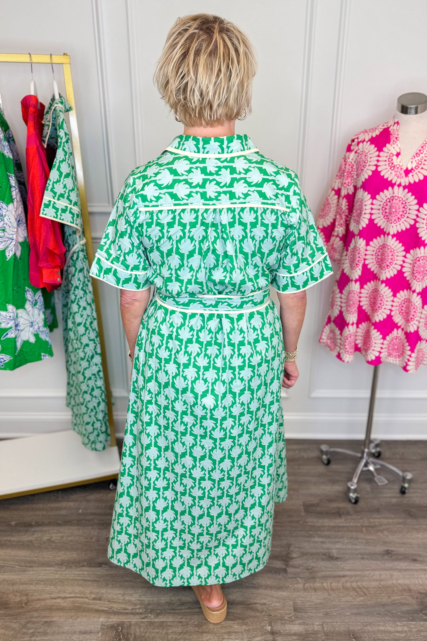 woman wearing green printed button down midi dress with tie detailing on a white background