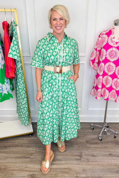 woman wearing green printed button down midi dress with tan stretch belt featuring a brown square buckle on a white background