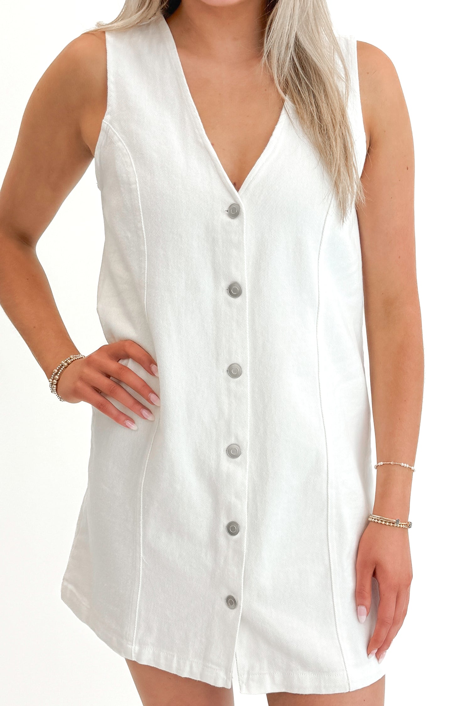 Front detail view of woman wearing White Denim Button Up Dress against white studio background.