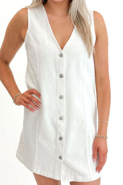 Front detail view of woman wearing White Denim Button Up Dress against white studio background.