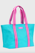 Blue tote bag with pink and white striped handles on a light gray background