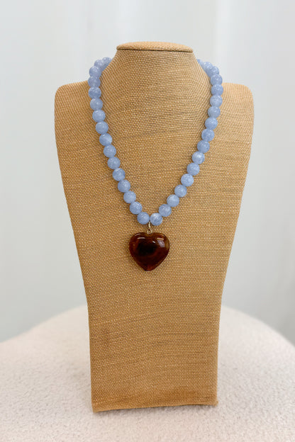 Necklace with a heart-shaped pendant on a beige mannequin bust against a white background