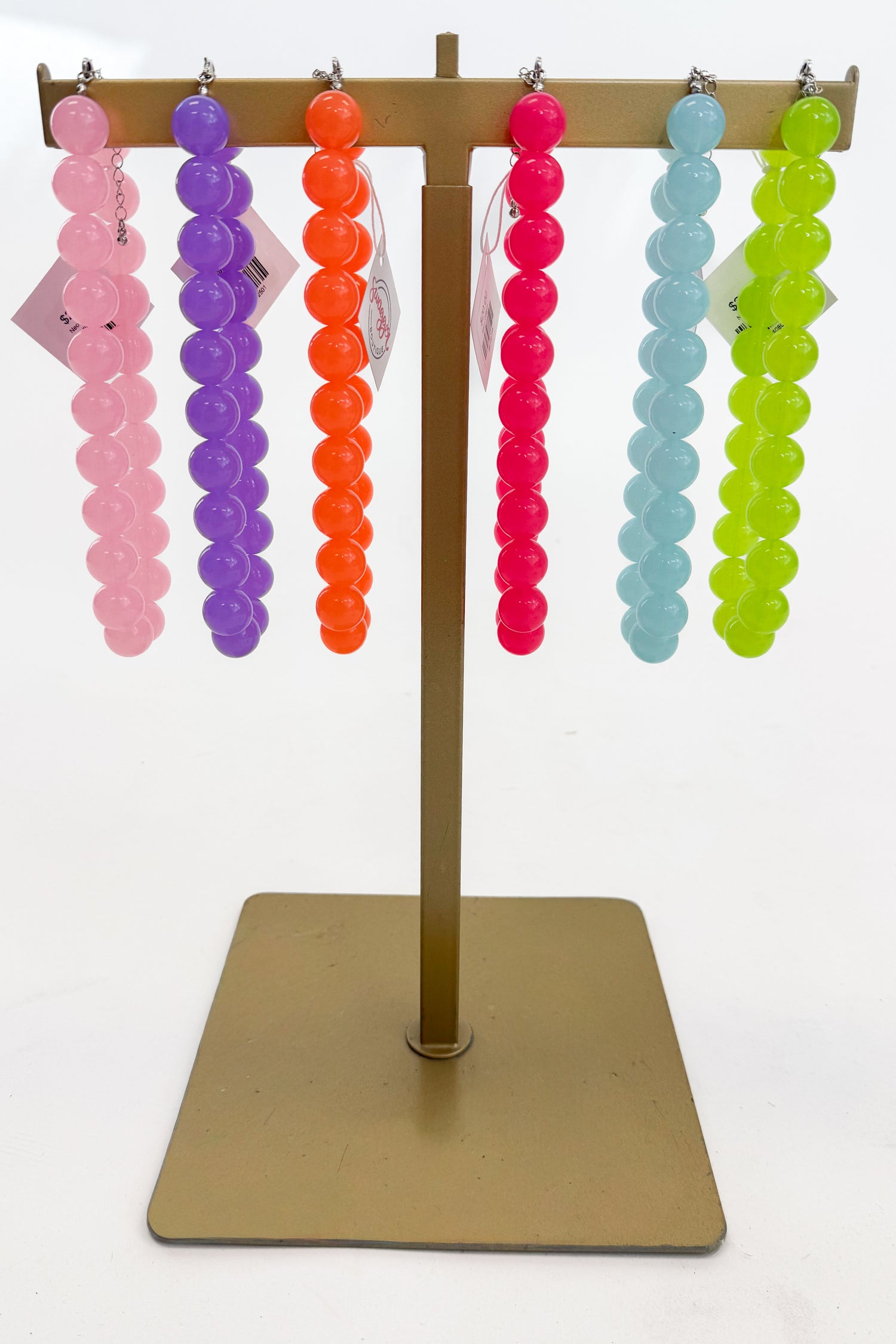 Colorful beaded earrings on a display stand against a white background