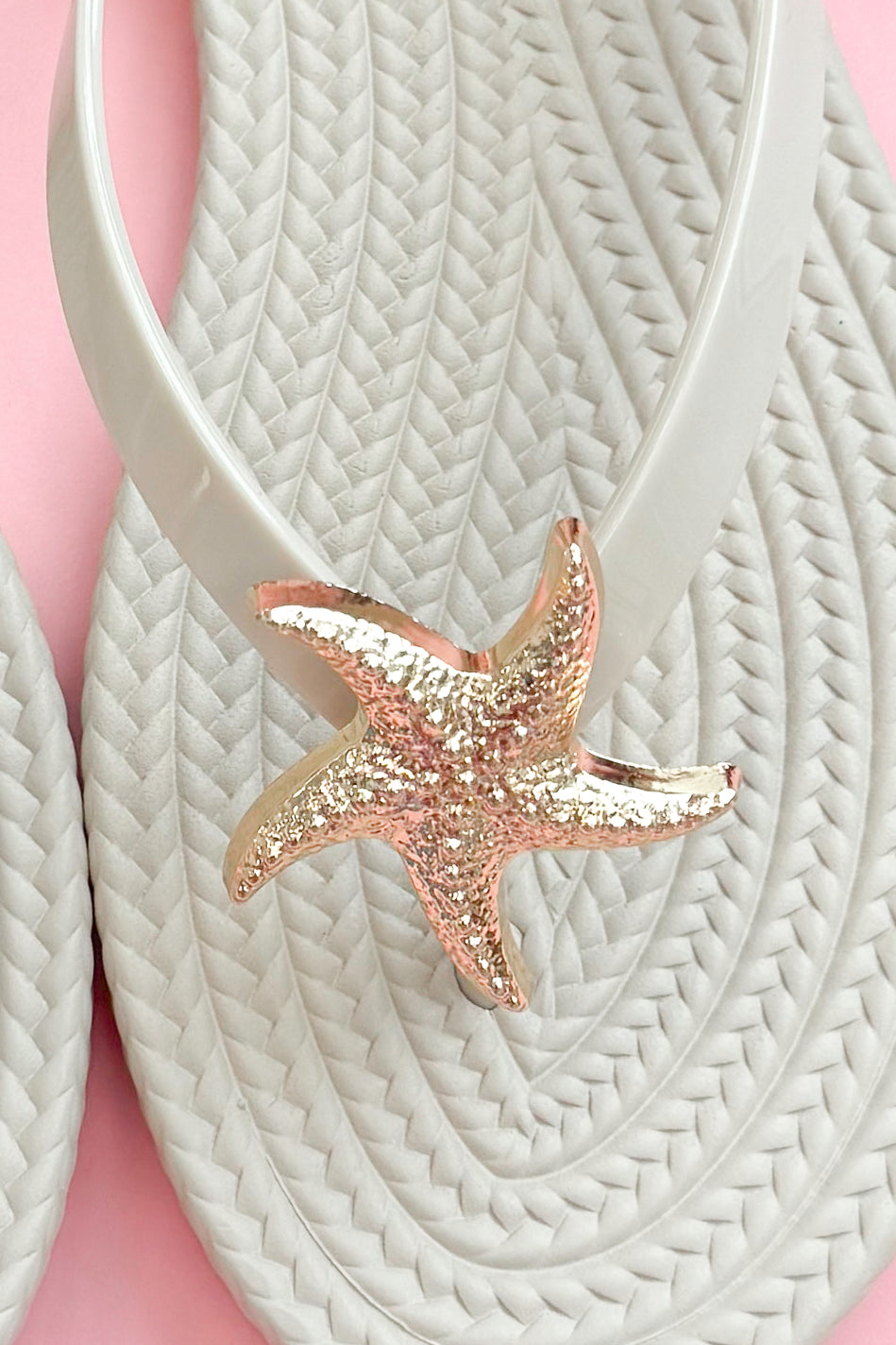 Nina- Ivory Shell Flip Flops against pink background detailed view