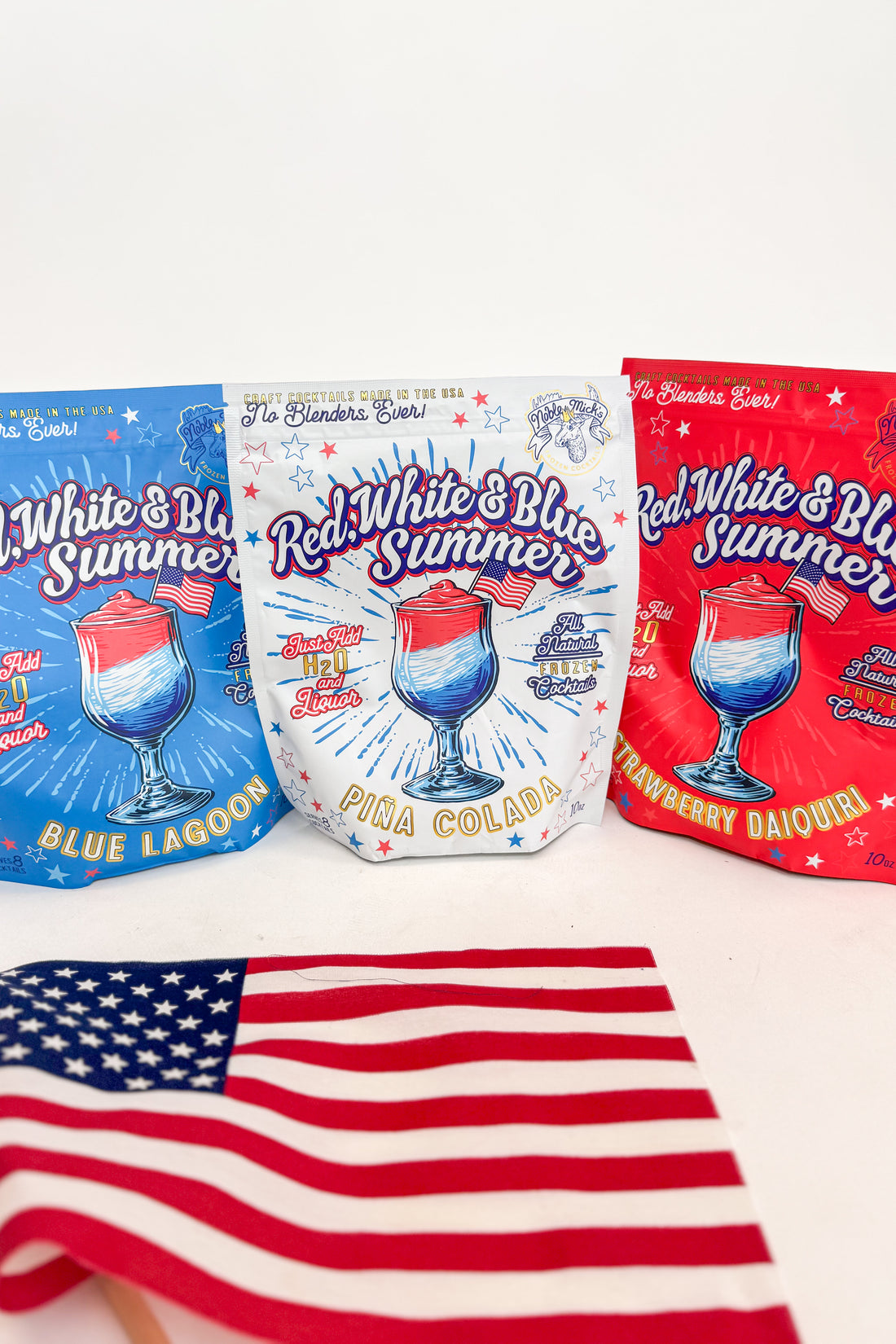 Three colorful packaging designs for drink mixes with a red, white, and blue theme, featuring an American flag in the foreground.