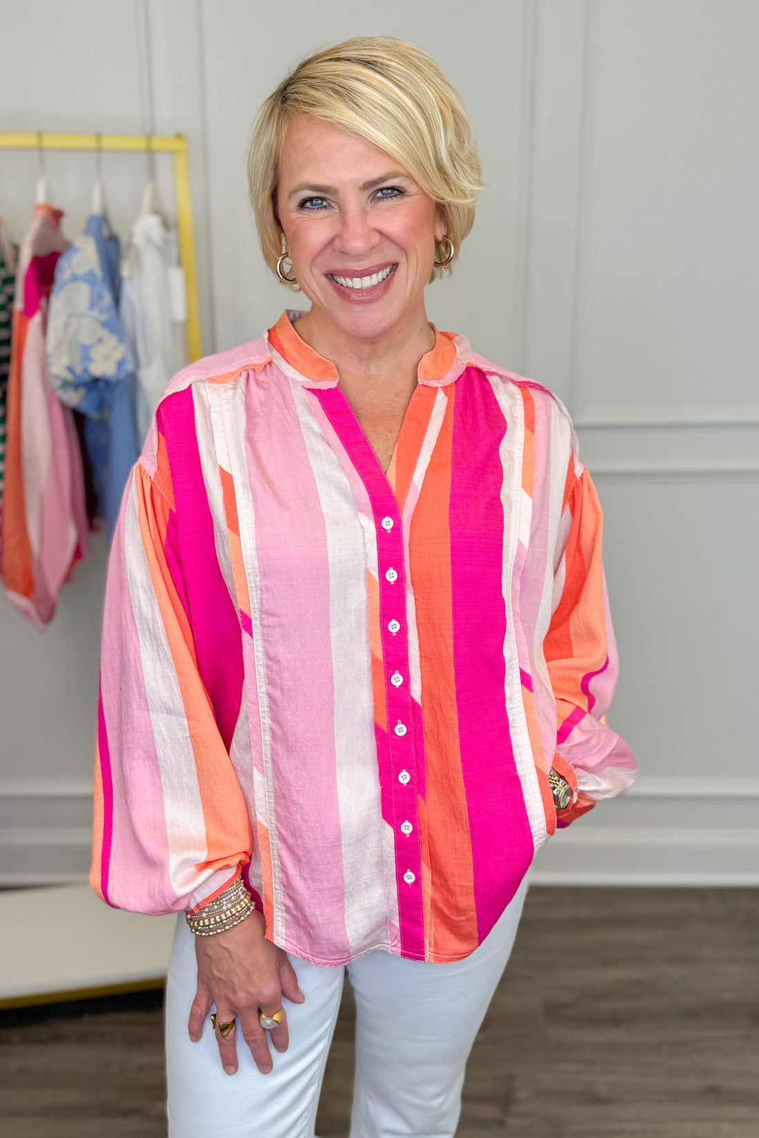 Woman wearing a colorful striped shirt in a clothing store.