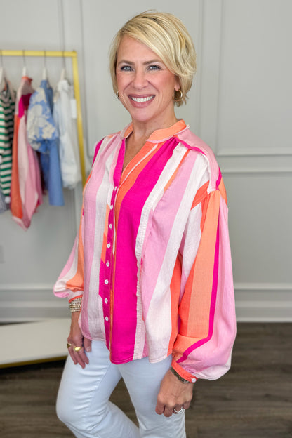 Woman wearing a colorful striped shirt in a clothing store.