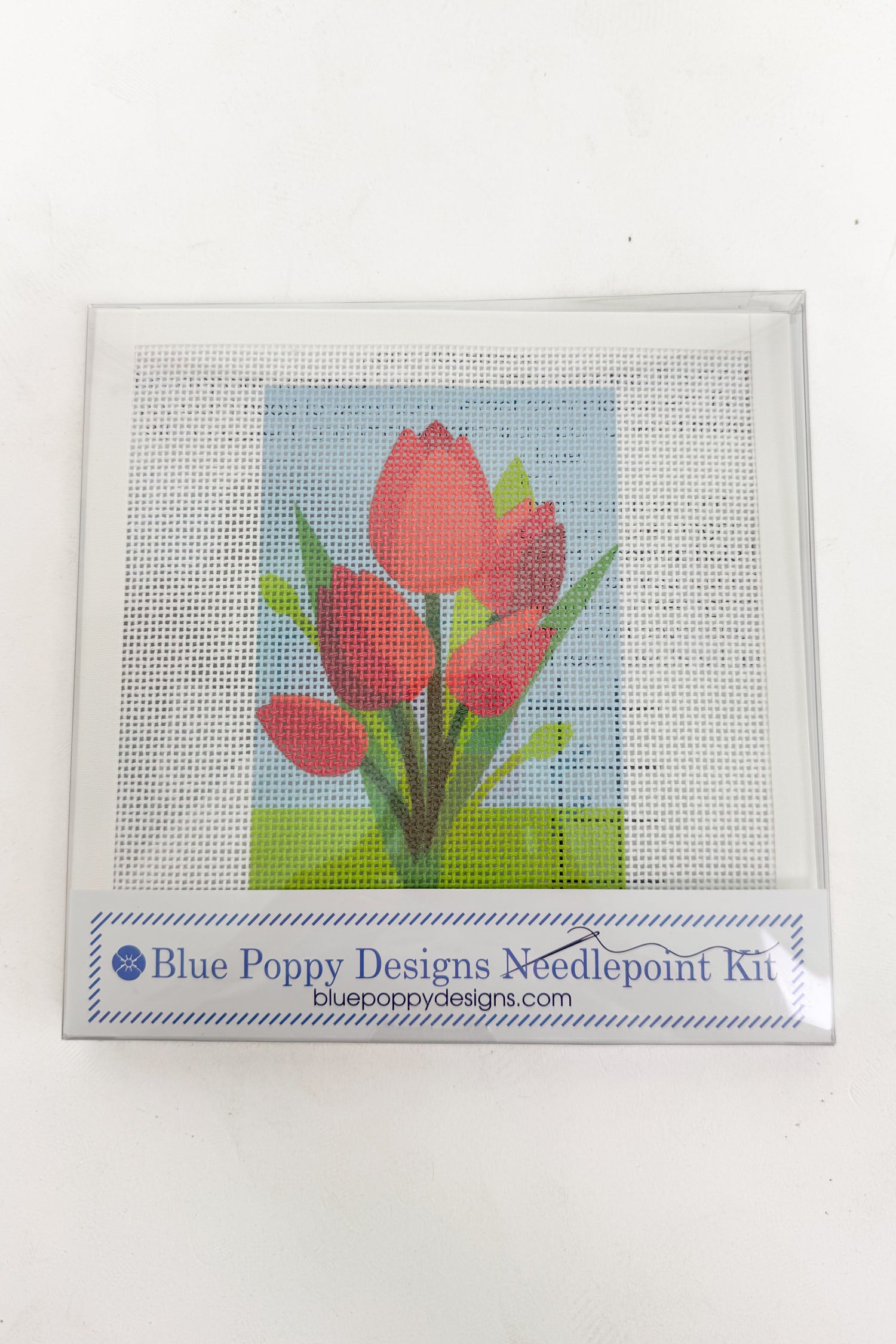Cross-stitched red tulips on a white background with &