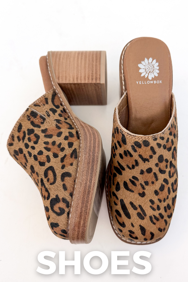 A pair of brown leopard-print slip-on mules with chunky block heels displayed against a white background. White text reads “SHOES.”