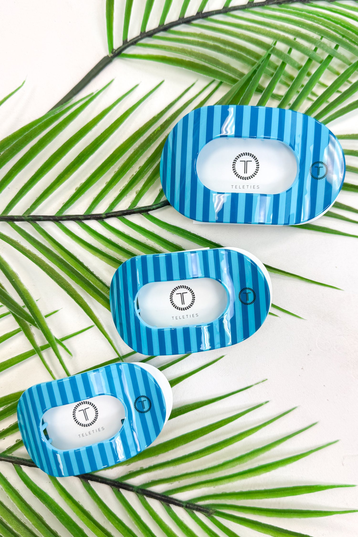 Blue and white striped hair clips on a leafy background