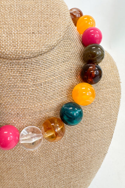 Colorful beaded bracelet on a mannequin head with a neutral background