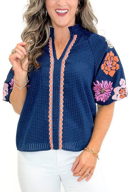 Front detail view of woman wearing Navy Textured &amp; Floral Embroidered Top by THML with jeans against white studio background.
