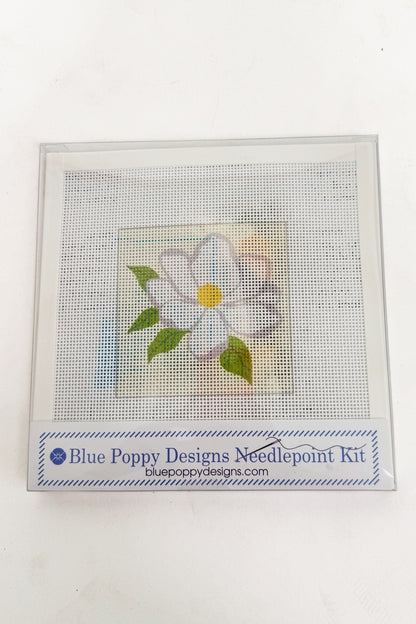 Needlepoint kit with a completed flower design on a white background